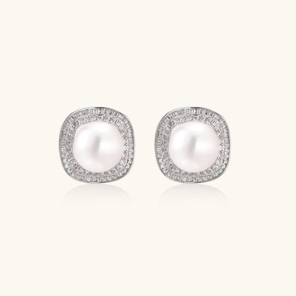 Rhodium-plated sterling silver stud earrings with round freshwater pearls surrounded by geometric crystal halos on cream background.