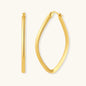 Set of geometric gold-plated sterling silver hoop earrings in oval and cushion shapes on cream background