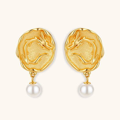 Ornate gold-plated dragon medallion earrings with white shell pearl drops on beige background, featuring detailed Chinese motifs.