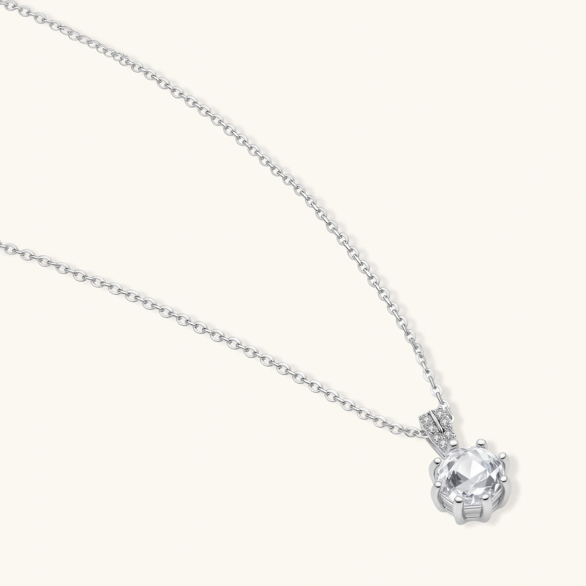 Platinum-plated sterling silver necklace with round clear crystal pendant and decorative bail on neutral background.