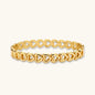 Gold 18K plated stainless steel bangle with continuous open heart links, high-polish finish, on white background.