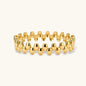 18K gold plated stainless steel bangle with dual rows of polished oval pebble beads on a cream background.