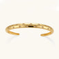 Polished 18K gold plated cuff bracelet with cubic zirconia set in star motifs on a cream background.